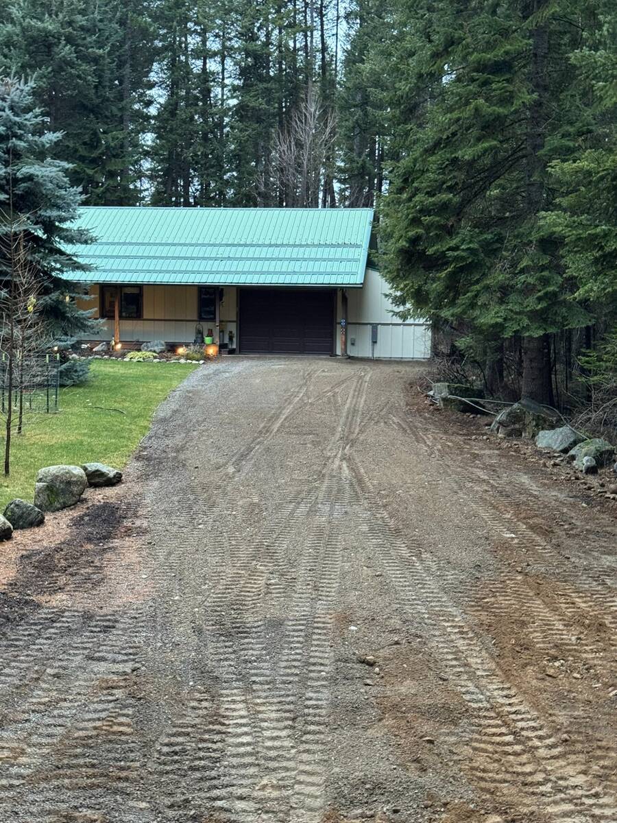 Caleb Hoffman, owner of Elkry Construction Coeur d'Alene Idaho, holding his son in front of his new CAT 305