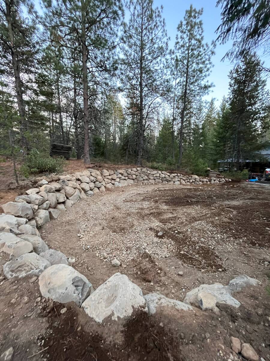 CAT skid steer on freshly graded gravel driveway at log cabin in North Idaho
