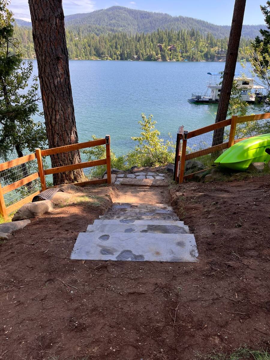 Finished concrete driveway with natural rock retaining wall at modern home in Coeur d'Alene Idaho