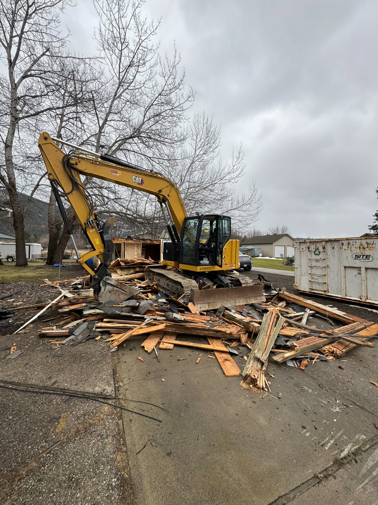 Elkry Construction CAT excavator performing structure demolition in North Idaho