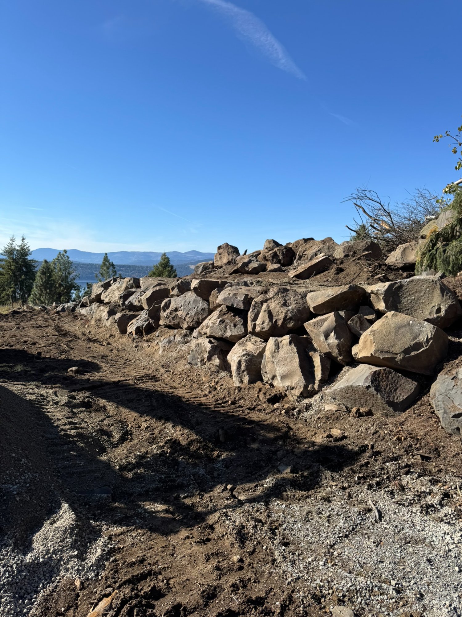 Natural rock retaining wall with Lake Coeur d'Alene and mountain views in background